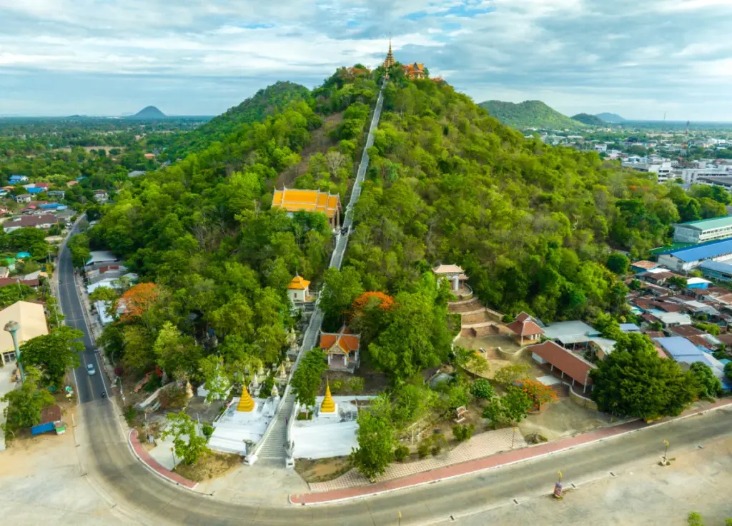 Large vue aérienne de la colline verdoyante de Khao Sakae Krang, de son temple doré et de la ville.
